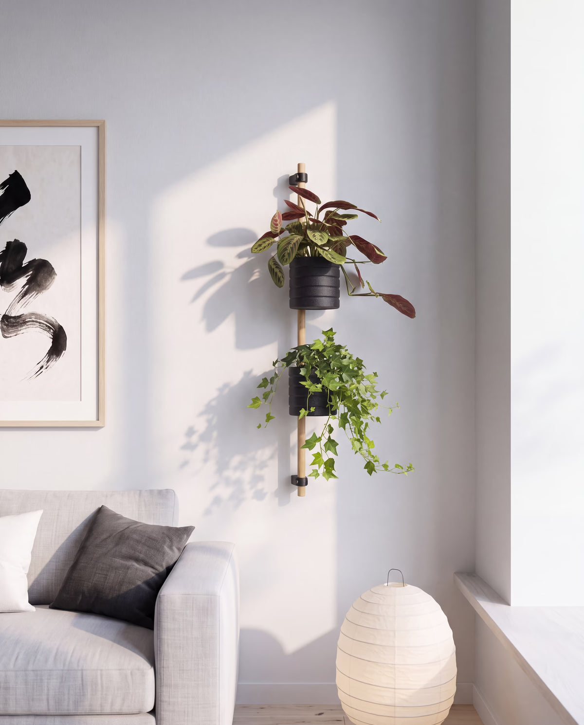 KIMU on a living room wall: oak rod with black wall brackets, a prayer plant on top and trailing ivy below
